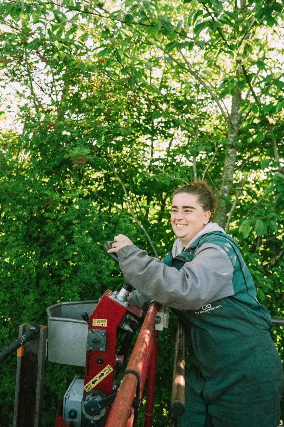 A smiling colleague on her tractor in the orchard
